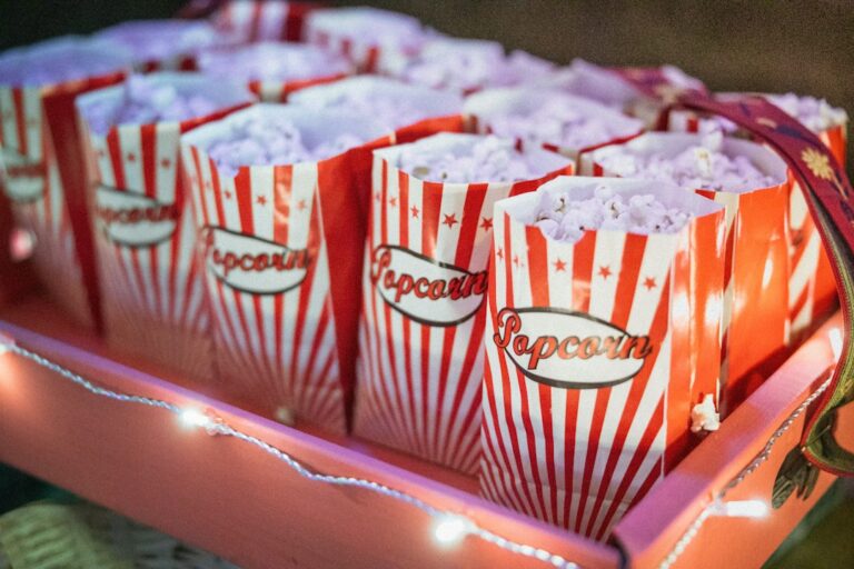 Red and white striped cartons filled with popcorn on a tray.