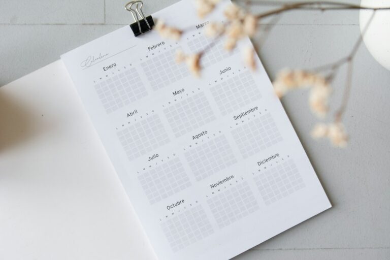 Printed annual calendar with Spanish month labels on a pale tabletop.