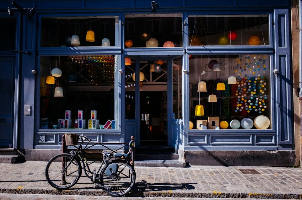 A blue shopfront with display windows and a bicycle parked outside.