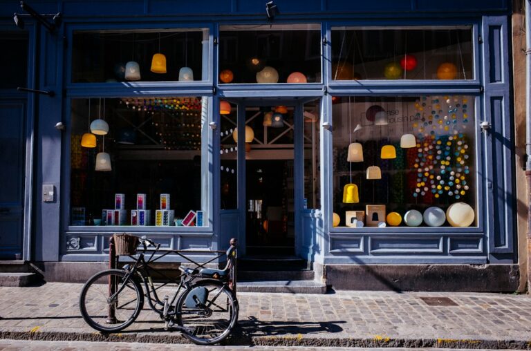 A blue shopfront with display windows and a bicycle parked outside.