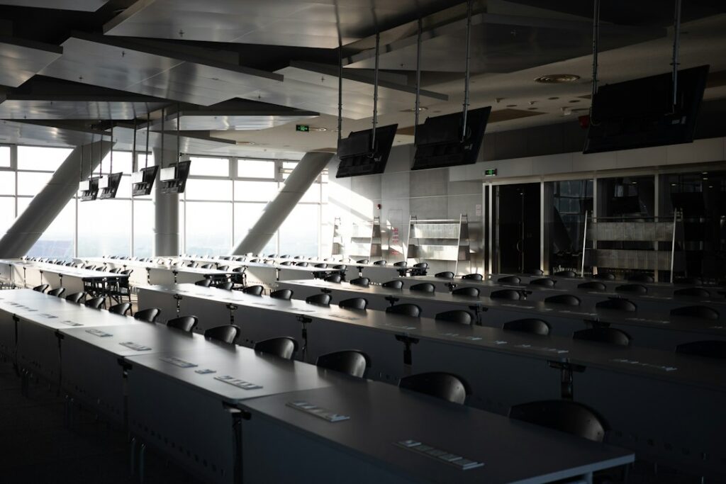 Rows of empty tables and chairs in a conference room