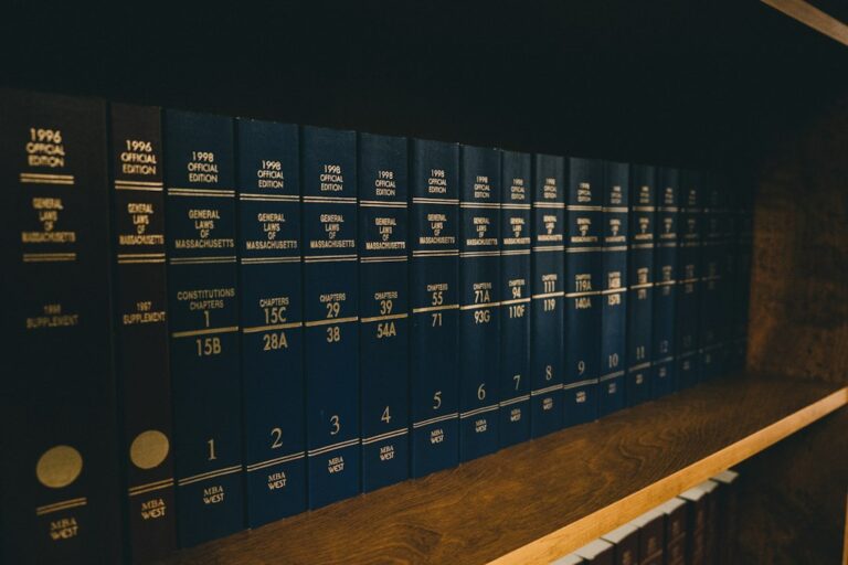 Bound volumes of Massachusetts laws arranged on a wooden library shelf.