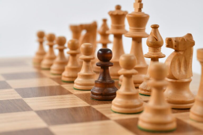 Wooden chess pieces arranged on a chessboard