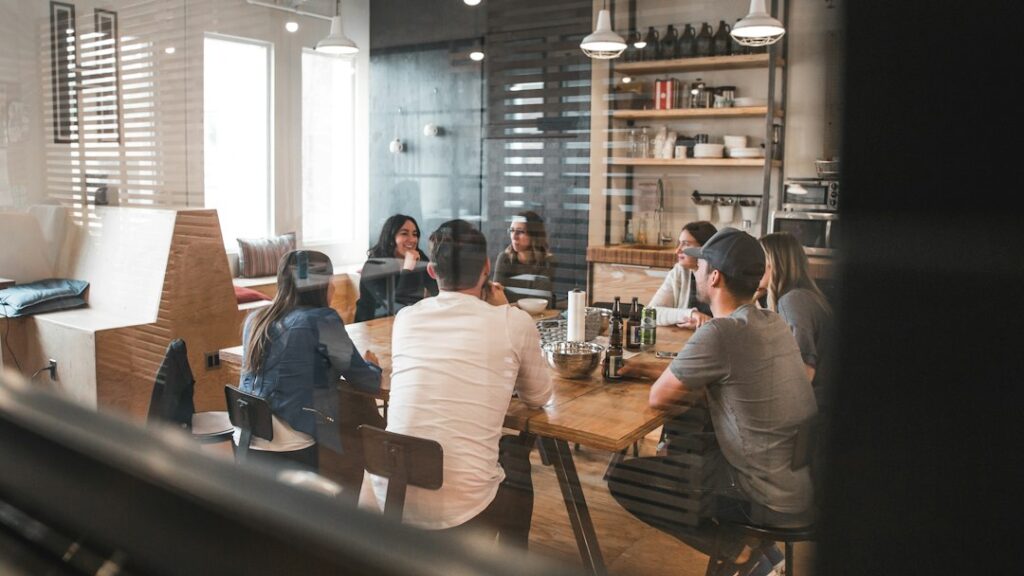Colleagues discussing work around a meeting table.