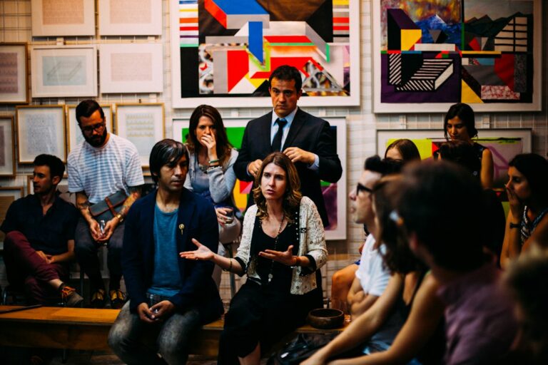 Adults seated and standing together during a group discussion.
