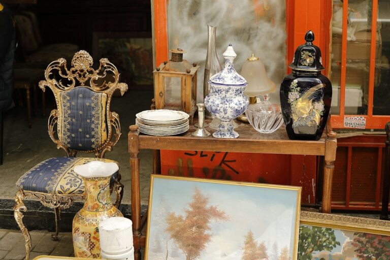 Secondhand vases, dishes, and framed pictures displayed at an outdoor market.