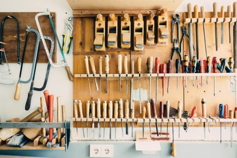 Hand tools arranged on a wooden wall rack.