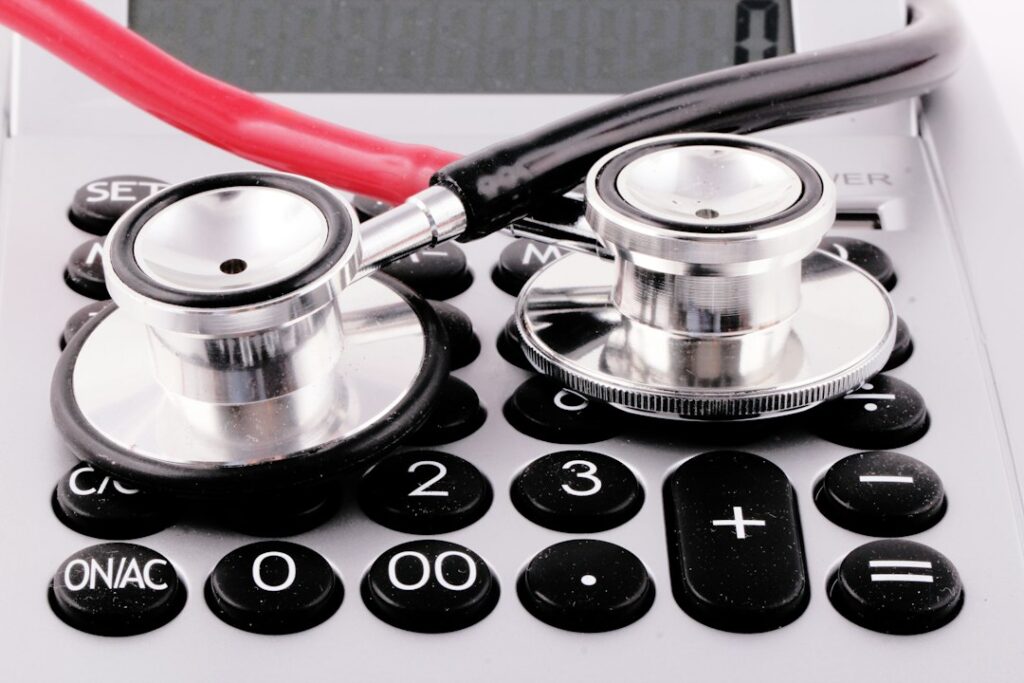 Two stethoscope chestpieces resting on a calculator.