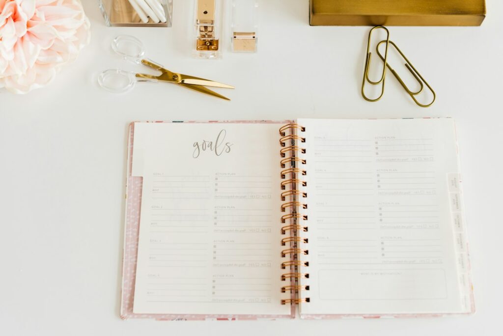 An open goal planner with blank action-plan fields and stationery.