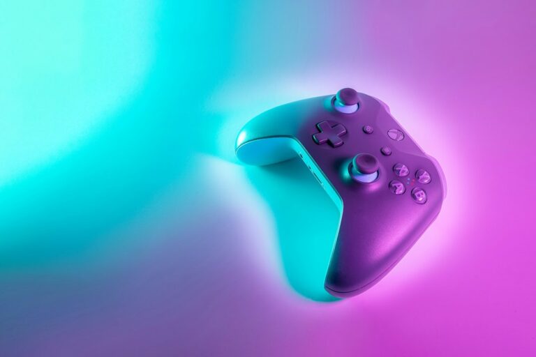 A game controller under blue and pink lighting.