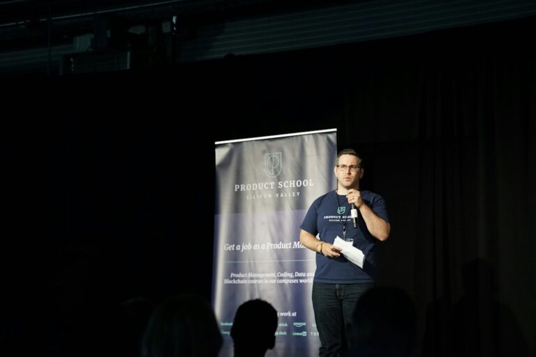 A speaker holding a microphone on a conference stage.