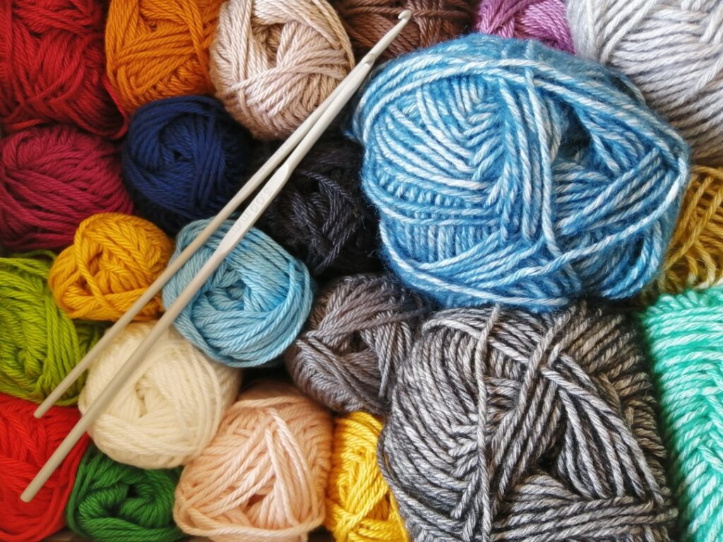 Colorful balls of yarn with two crochet hooks.