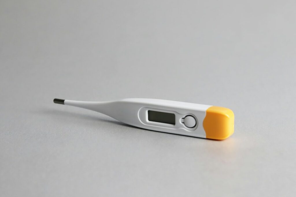 A digital thermometer lying on a plain surface
