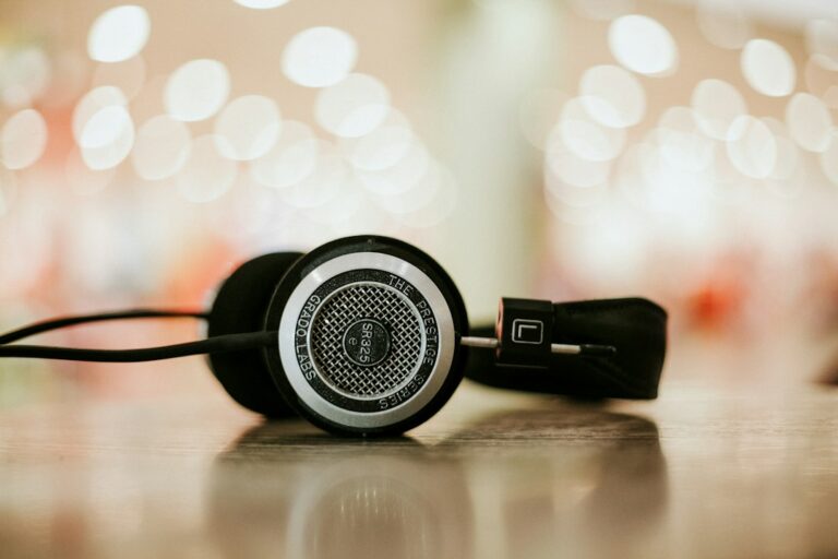 Over-ear headphones resting on a wooden tabletop.