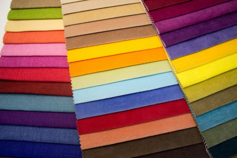 Overlapping fabric swatches in a range of bright and neutral colors.