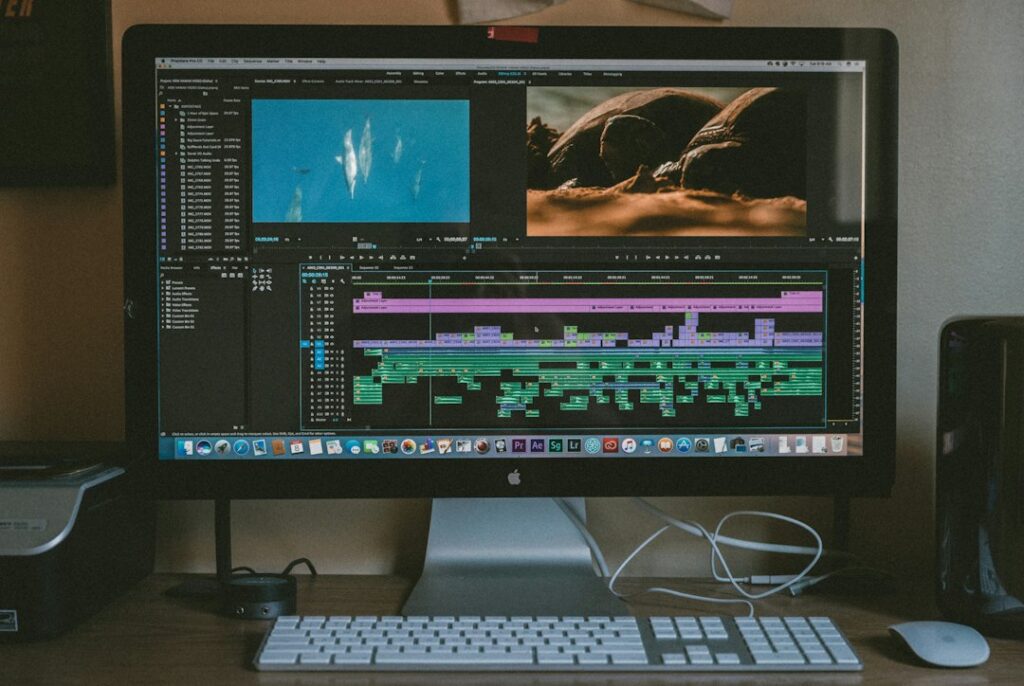 Desktop monitor showing a video-editing timeline with multiple audio and video tracks.
