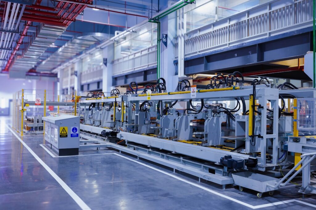 Industrial machinery and overhead pipes along a factory production line.