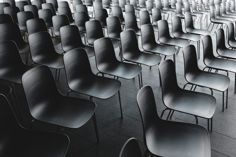 Rows of empty gray chairs arranged inside an event room.