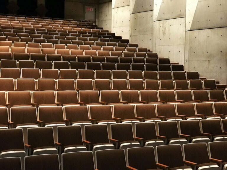 Rows of empty brown seats inside an auditorium.