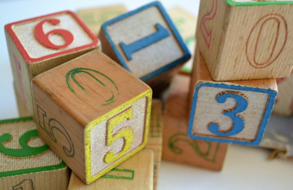 Wooden blocks displaying numbers and letters arranged together.