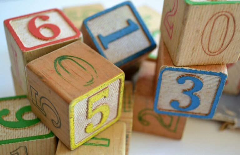 Wooden blocks displaying numbers and letters arranged together.