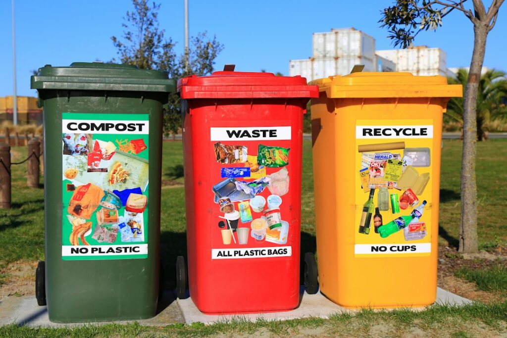 Green, red, and yellow bins labeled compost, waste, and recycle.