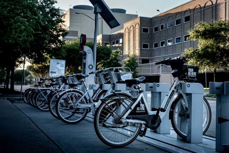 Shared bicycles parked in a row at an outdoor docking station.