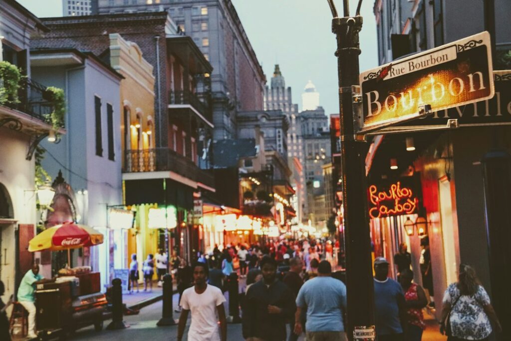 People walking along a busy street lined with shops and signs.