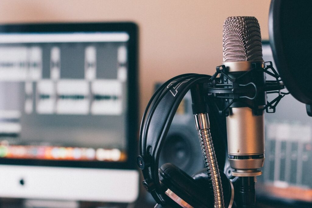 Studio microphone and headphones in front of a computer.