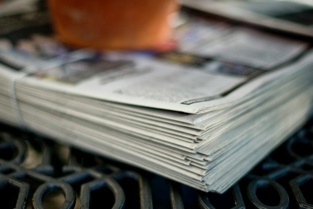 A stack of folded newspapers on an outdoor table