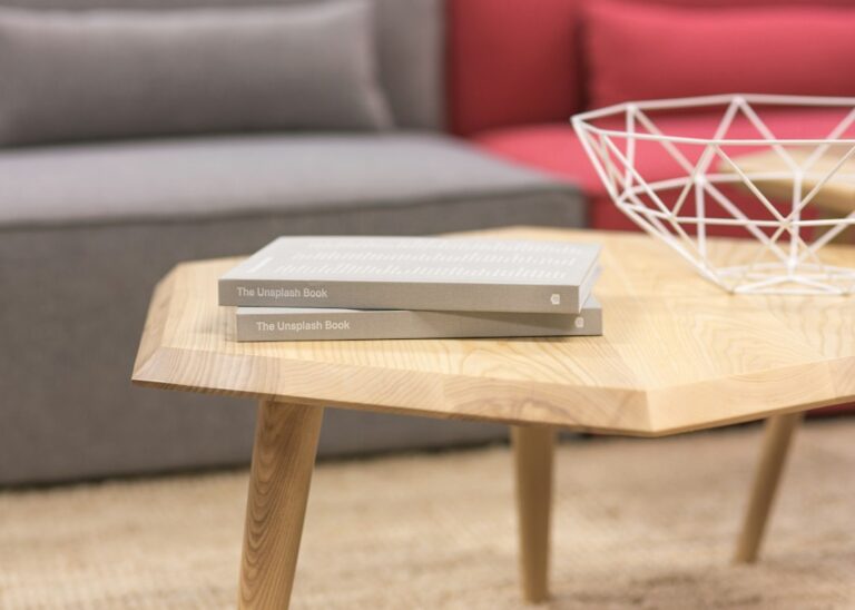 Two books on a wooden coffee table beside a wire basket.