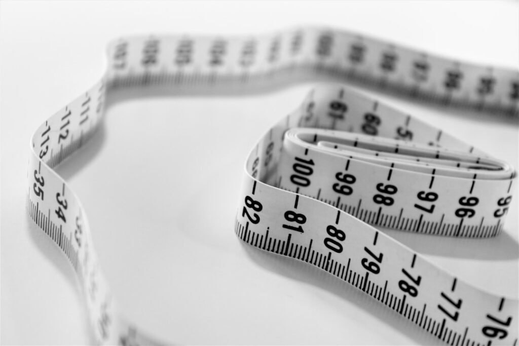 Coiled measuring tape on a white surface