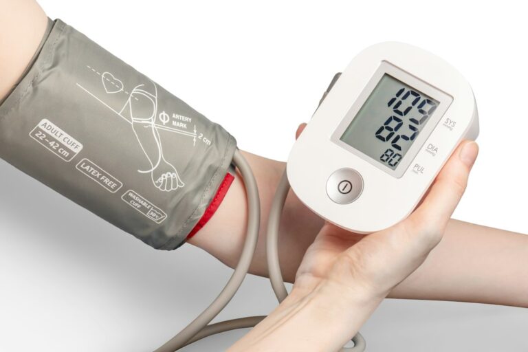 Close-up of an arm cuff and a handheld blood pressure monitor