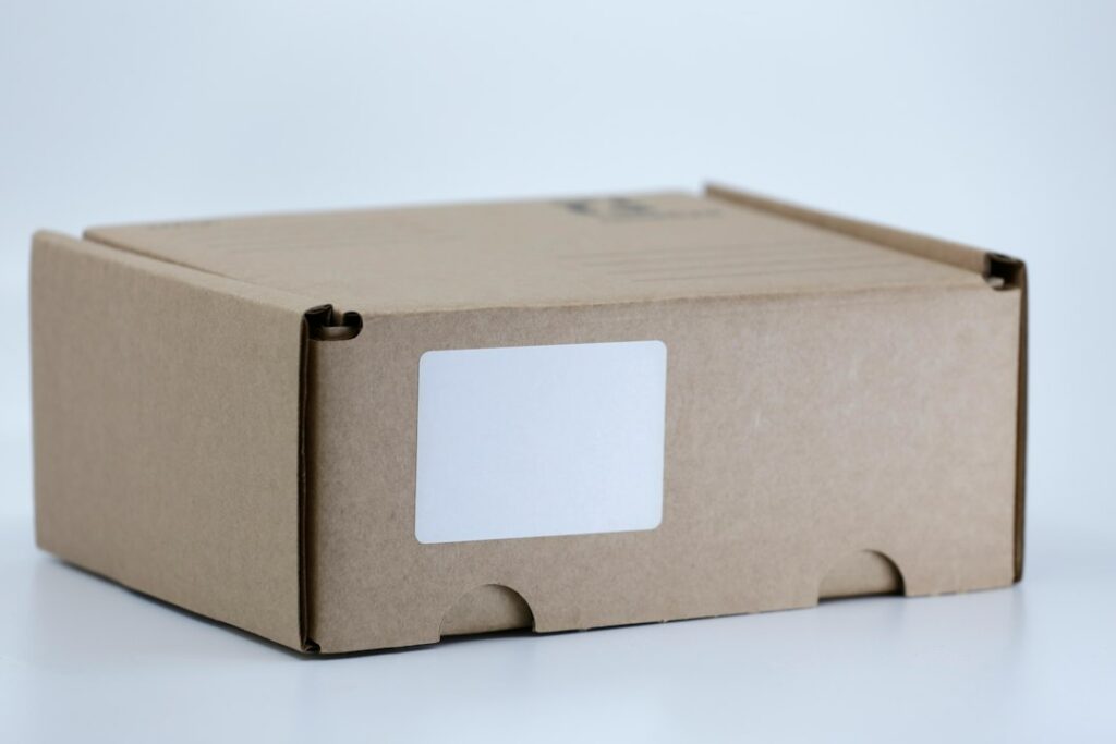 Closed cardboard shipping box with a blank white label