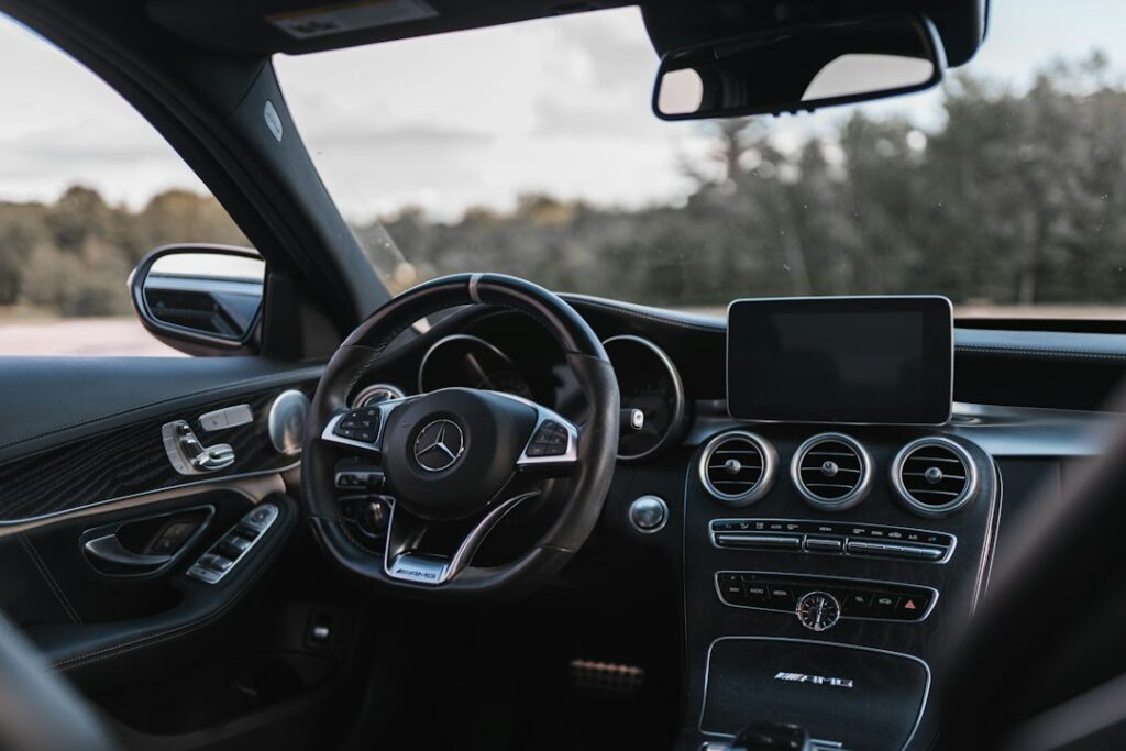 Steering wheel and dashboard inside a parked car with an empty driver seat
