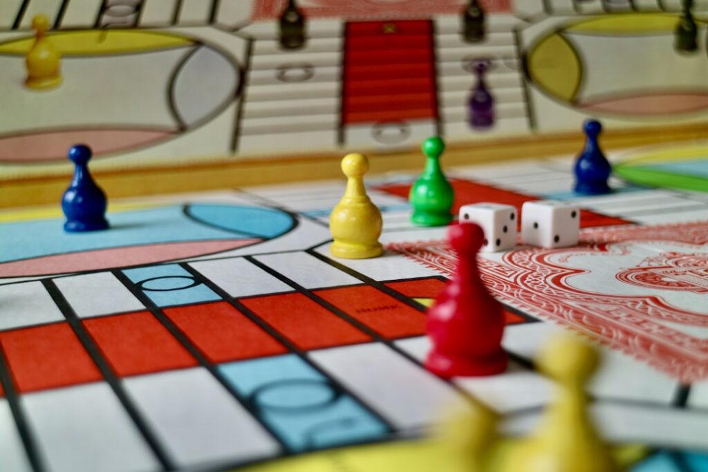 Colored game pieces and dice on a Parcheesi board