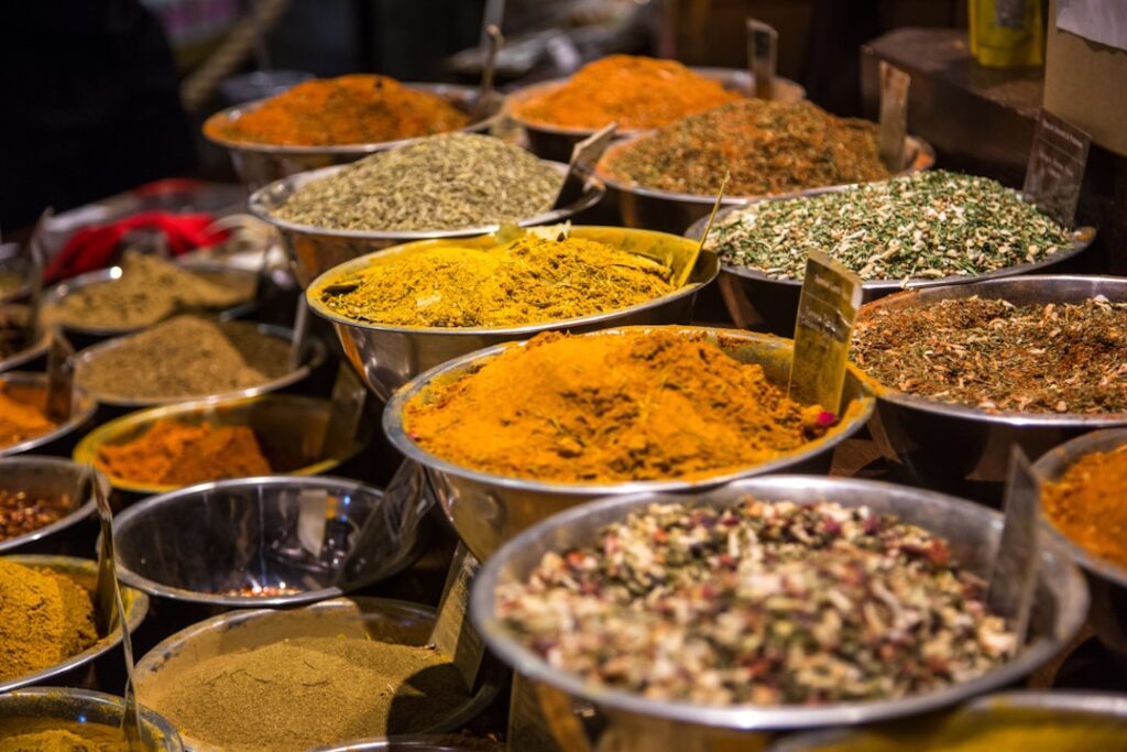 Bowls filled with colorful ground spices and dried herbs at a market