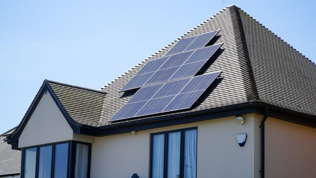 Solar panels mounted on the tiled roof of a house.