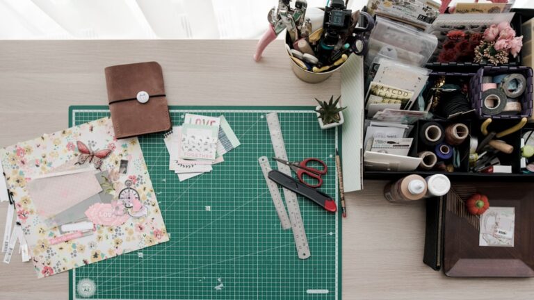 Paper, scissors and craft supplies arranged around a cutting mat