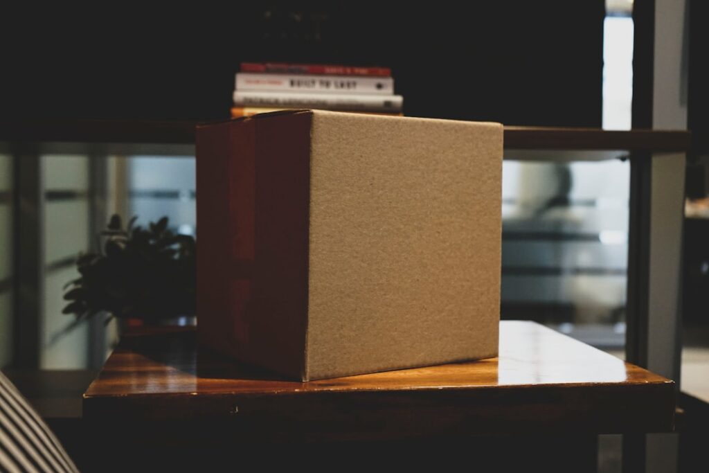 An unmarked cardboard box on a wooden surface in an office.