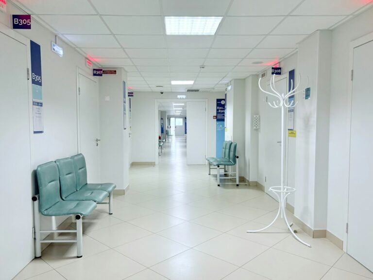 Empty hospital corridor with seating and closed doors