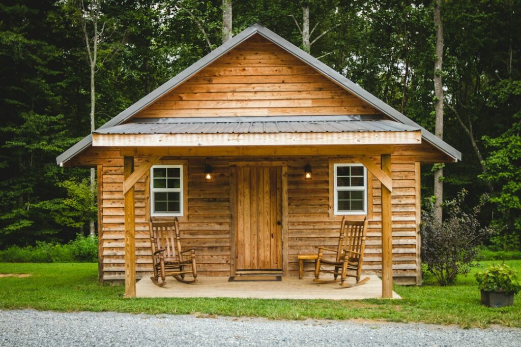 Small wooden cabin with two rocking chairs on its covered porch