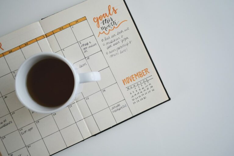 A cup of coffee beside an open handwritten planner.