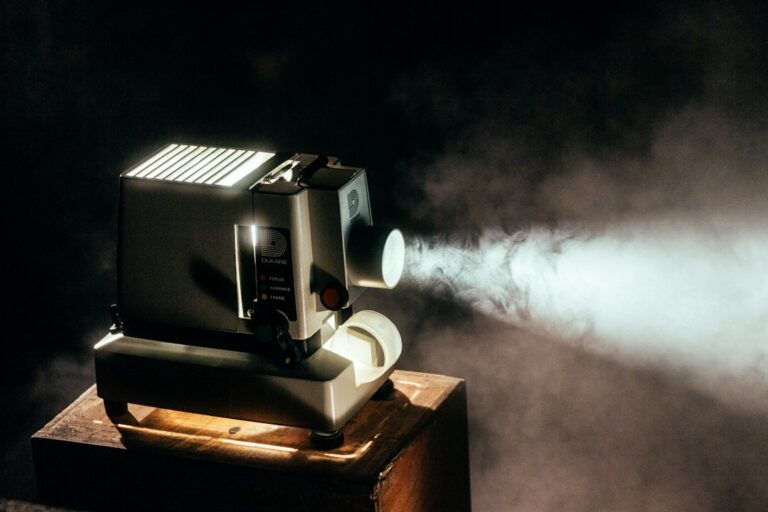 A vintage projector casting a beam of light in a dark room.