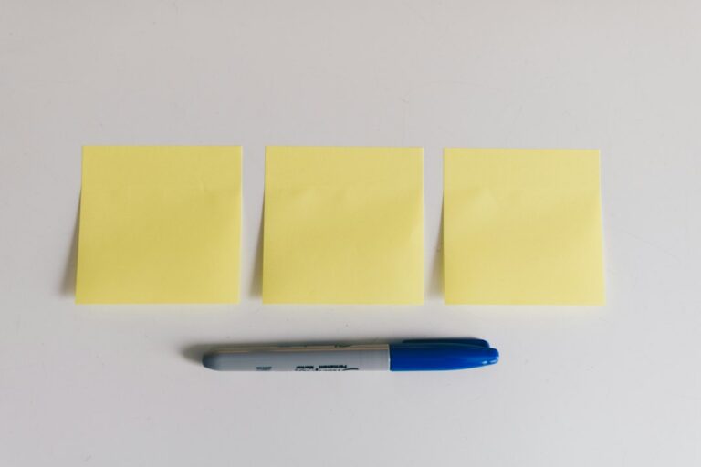 Three blank yellow sticky notes with a blue marker.