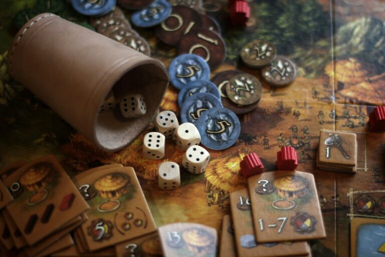 Dice, cards, and tokens arranged on a tabletop board game.