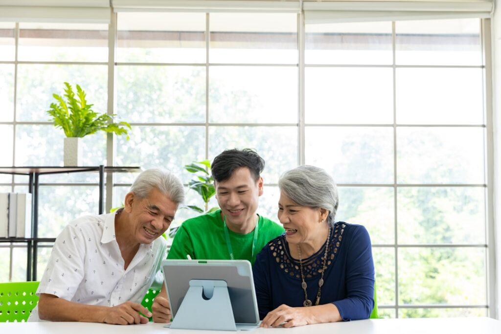 Three adults looking at a tablet together.