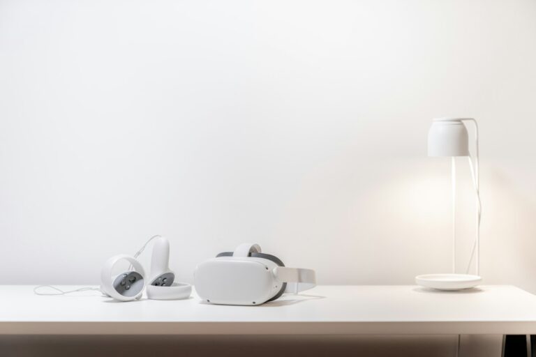 A white virtual-reality headset and two controllers resting on a desk