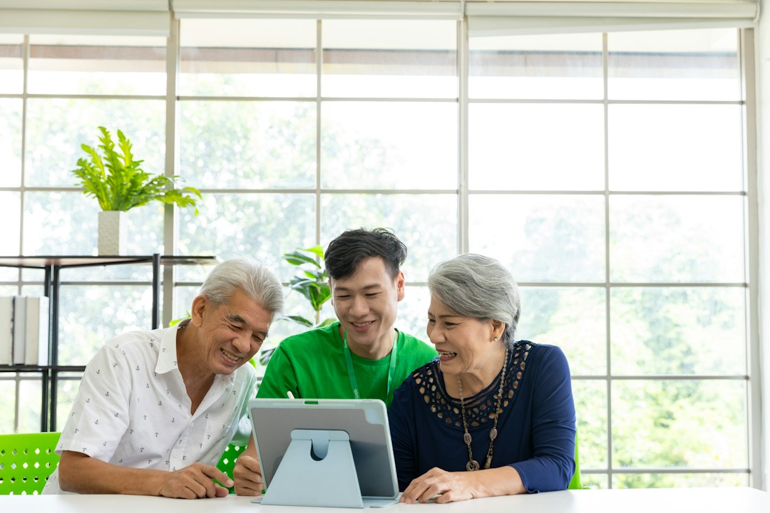 Adults looking at a tablet together in a bright setting.