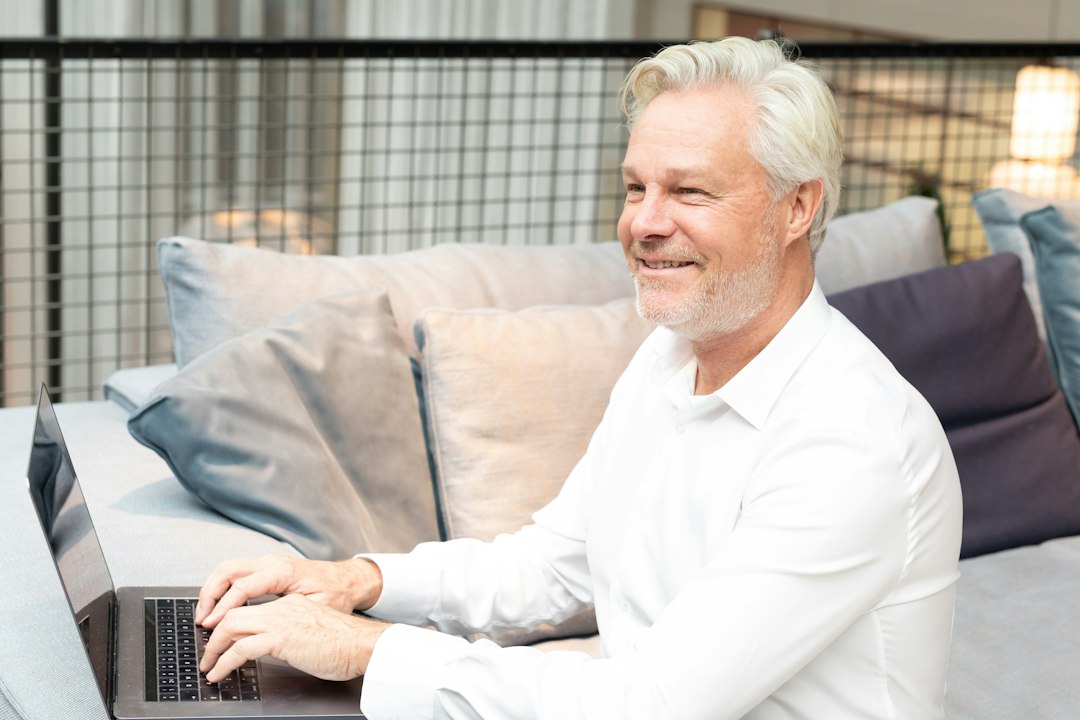 Adult using a laptop in a relaxed home setting.